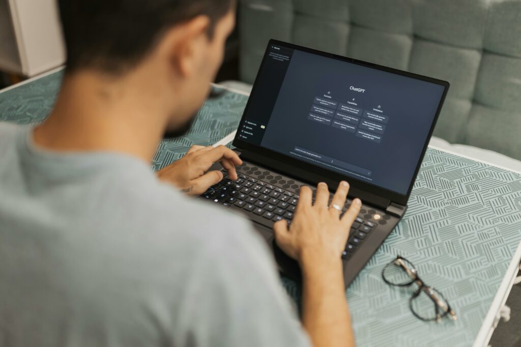 Man working at home office, using laptop with ChatGPT